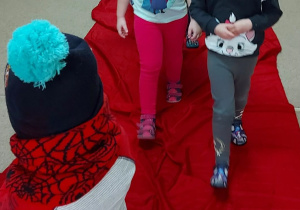 dzieci prezentują zimowed stroje na "czewonym dywanie"